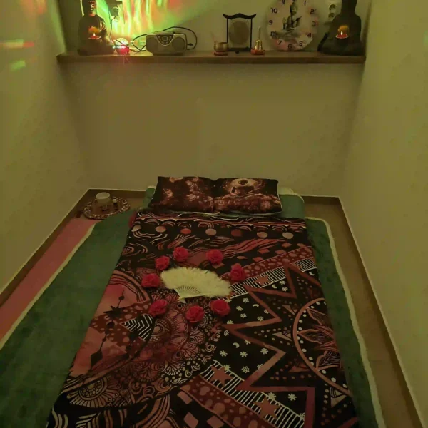 Atmosférický detail sviečok a dekorácií vytvárajúcich pokoj a sústredenie počas tantra masáže.