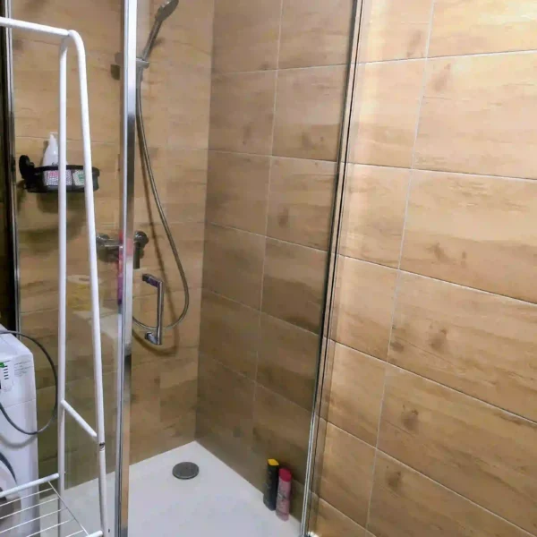 Kúpeľňa so sprchou: Čistá a elegantná kúpeľňa so sprchou v tantrickom štúdiu v Žiline, pripravená pre klientov po masáži.